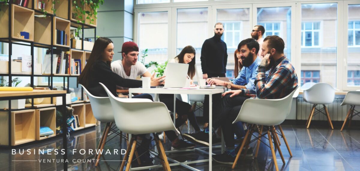 A group of people sitting around a table in an office.